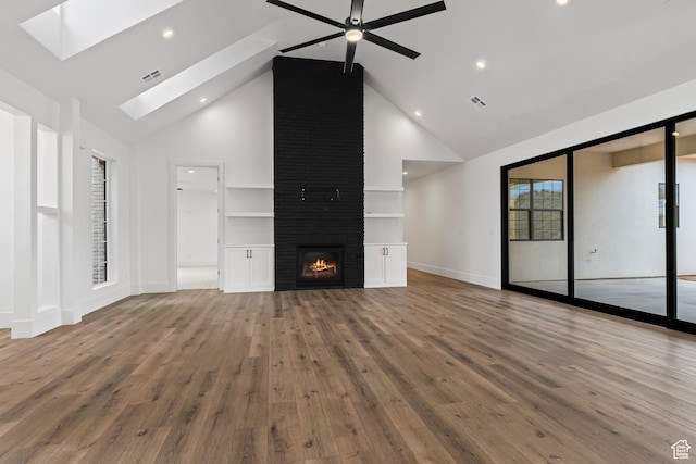 1539 W 2130th Cir S, St George, UT 84770 - unfurnished living room with a skylight, a large fireplace, high vaulted ceiling, and wood-type flooring