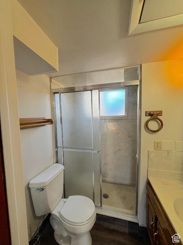 full bath with toilet, a stall shower, wood finished floors, and vanity
