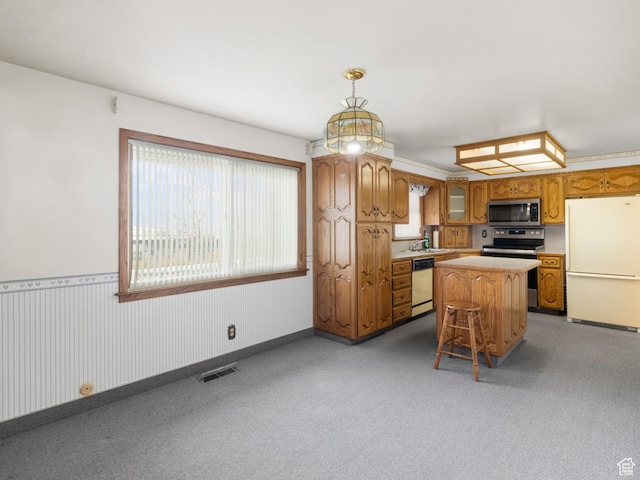 5304 W 20400 N, Plymouth, UT 84330 - kitchen with stainless steel appliances, light colored carpet, decorative light fixtures, a center island, and a breakfast bar area