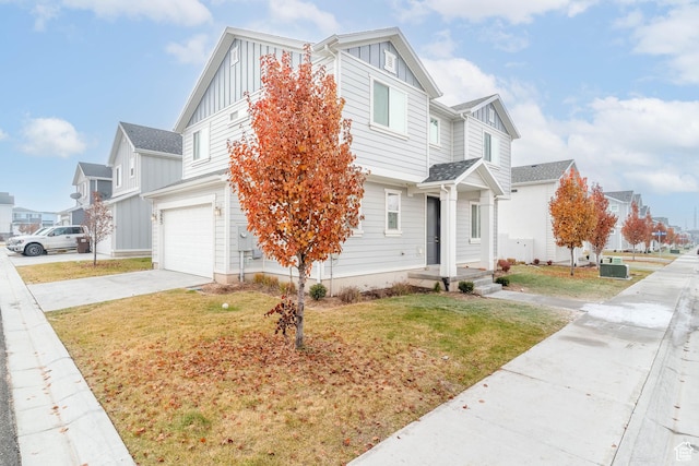 view of front of property with central AC unit, a front yard, and a garage