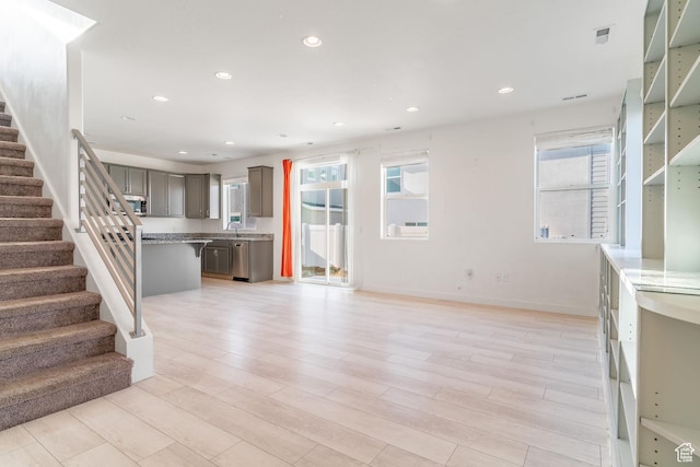 unfurnished living room featuring sink and light wood-type flooring