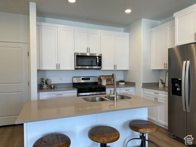 1056 E 1930 S Unit 420, Heber City, UT 84032 - kitchen featuring stainless steel appliances, a kitchen breakfast bar, white cabinets, recessed lighting, and an island with sink