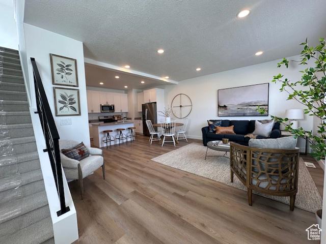 1056 E 1930 S Unit 420, Heber City, UT 84032 - living area with stairway, wood finished floors, a textured ceiling, and recessed lighting