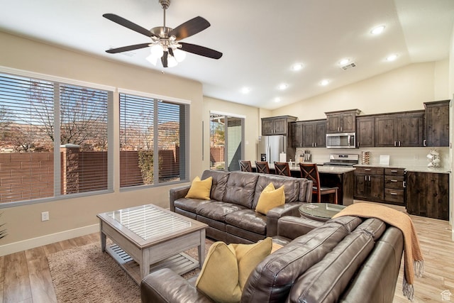 living room featuring light hardwood / wood-style floors, ceiling fan, and lofted ceiling