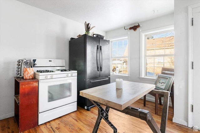 38 S State St W, Fairview, UT 84629 - kitchen featuring light hardwood / wood-style floors, black refrigerator, and white gas range