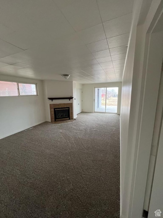 220 S 100 E, Tooele, UT 84074 - unfurnished living room featuring carpet floors and a tiled fireplace