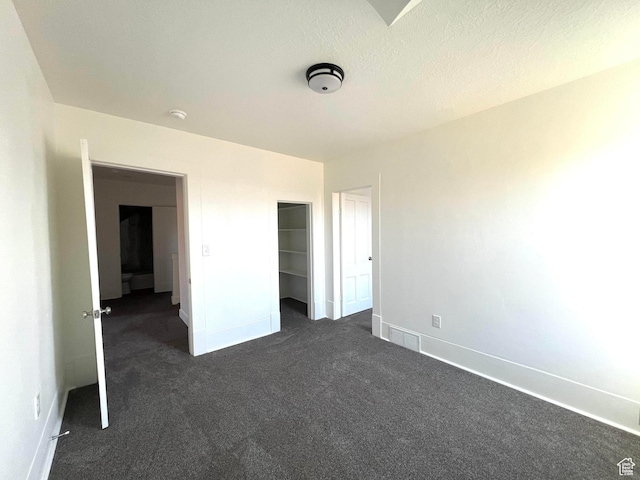 196 W 100 N, Providence, UT 84332 - unfurnished bedroom featuring dark colored carpet, a textured ceiling, and a closet