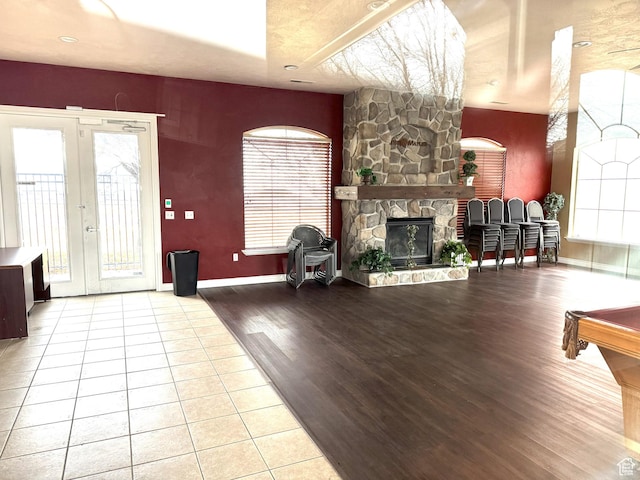 living room with light hardwood / wood-style floors, a fireplace, and french doors