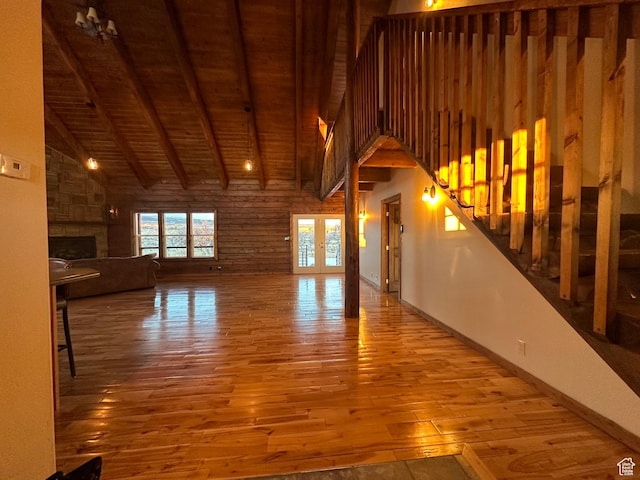 unfurnished living room featuring wood ceiling, a large fireplace, beam ceiling, high vaulted ceiling, and hardwood / wood-style floors