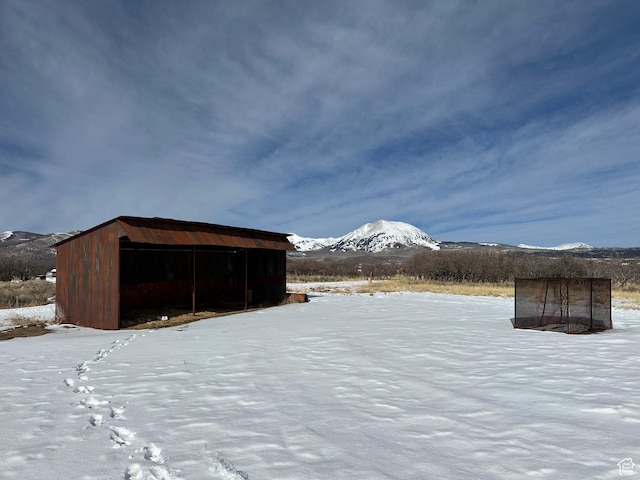 snow covered structure featuring a mountain view