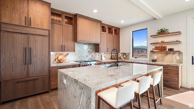 2072 E Copper Belt Dr, Heber City, UT 84032 - kitchen featuring backsplash, a kitchen breakfast bar, sink, paneled built in refrigerator, and an island with sink