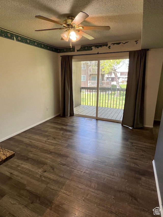 spare room featuring baseboards, a ceiling fan, a textured ceiling, and dark wood-style floors