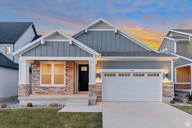 craftsman-style house with stone siding, an attached garage, concrete driveway, board and batten siding, and covered porch