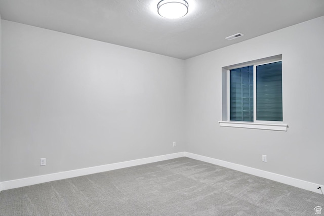 carpeted empty room featuring baseboards and visible vents