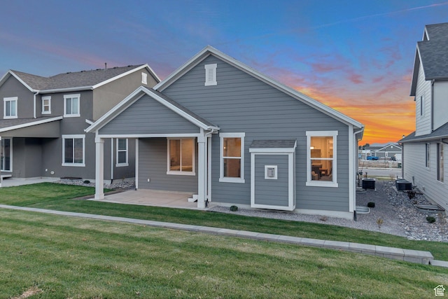 view of front of house featuring a front yard, central AC, and a patio