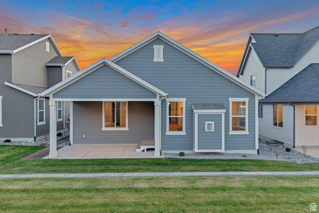 back of property featuring a lawn and a patio