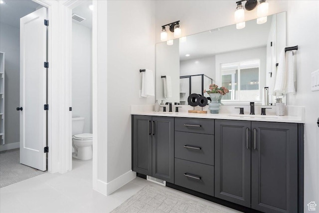 full bath with toilet, a sink, a stall shower, visible vents, and double vanity