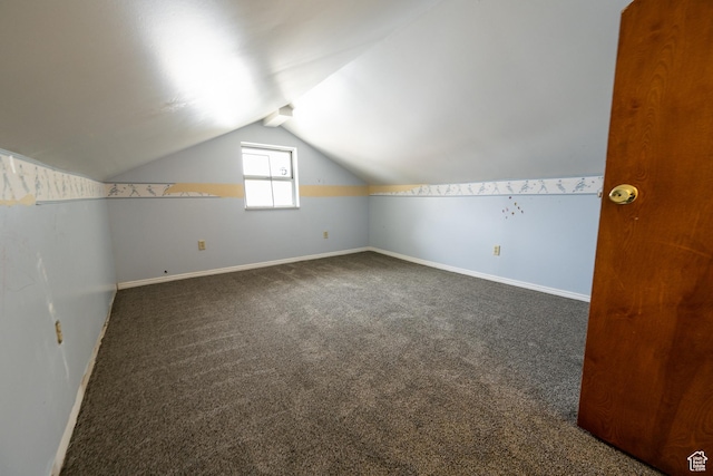 bonus room featuring vaulted ceiling and dark carpet