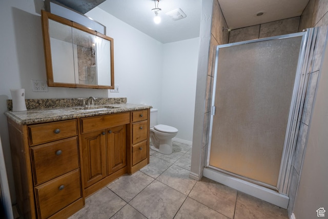 bathroom with tile patterned flooring, vanity, toilet, and a shower with shower door