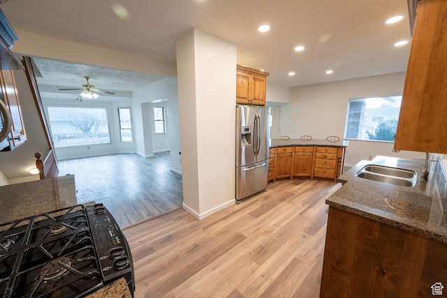 kitchen with stainless steel fridge, light wood-type flooring, plenty of natural light, and sink