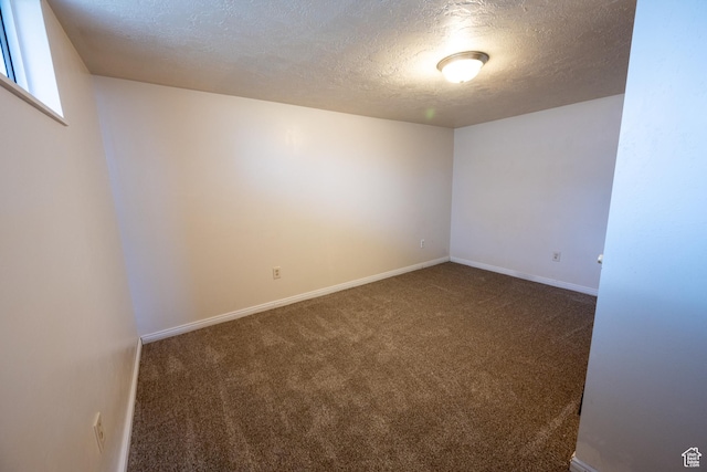 carpeted spare room with a textured ceiling