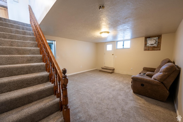 interior space featuring a textured ceiling and carpet floors