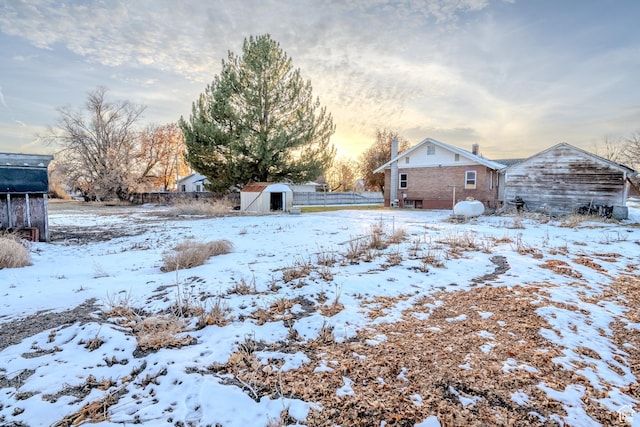 yard covered in snow featuring a storage unit