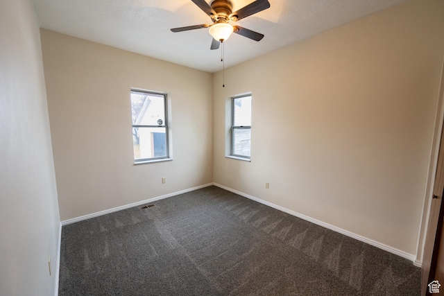 carpeted spare room featuring ceiling fan