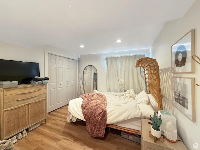 bedroom featuring light wood-style flooring, arched walkways, a closet, and recessed lighting