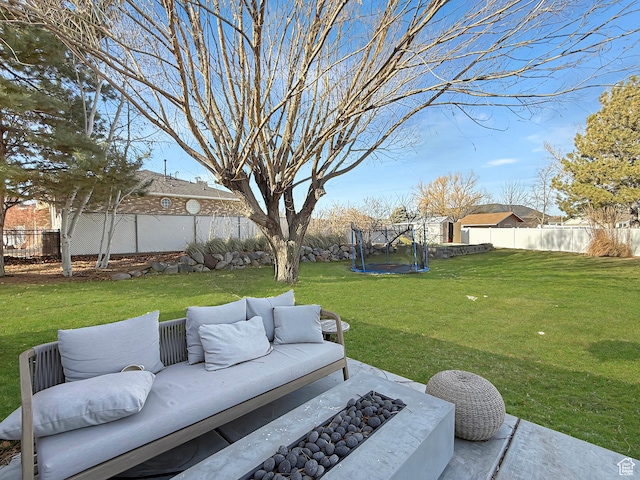 view of yard with a trampoline, a fenced backyard, and an outdoor living space