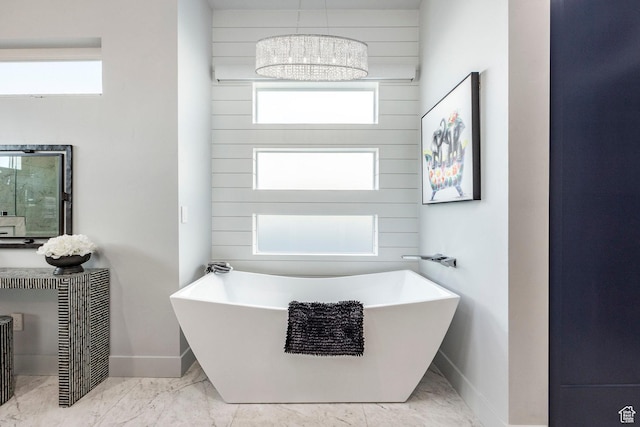 bathroom featuring a bathtub and an inviting chandelier
