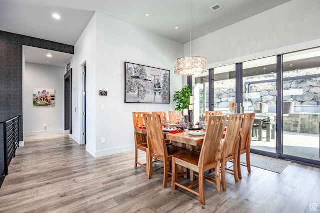 dining area with light wood-type flooring and a chandelier