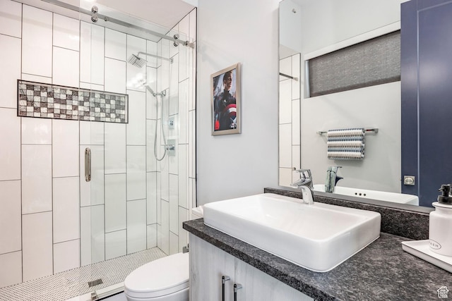 bathroom with vanity, toilet, and a shower with shower door