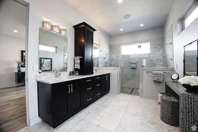 bathroom with tiled shower and vanity