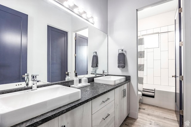 full bathroom with vanity, wood-type flooring, shower / tub combo, and toilet