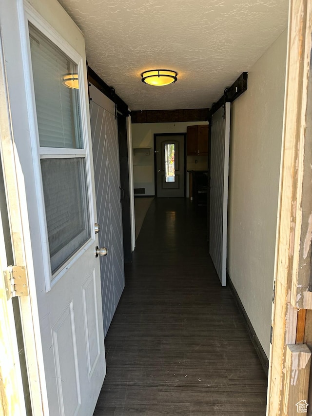 45 W Main St, Moroni, UT 84646 - hallway featuring a textured ceiling, a barn door, and dark hardwood / wood-style flooring