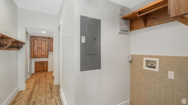 clothes washing area with washer hookup, electric panel, light hardwood / wood-style flooring, and baseboard heating
