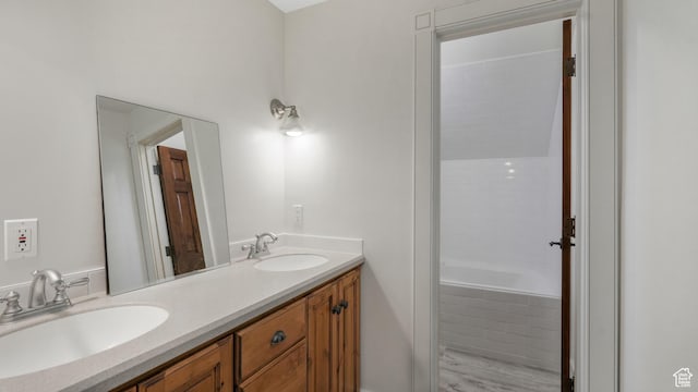 bathroom with vanity and a relaxing tiled tub