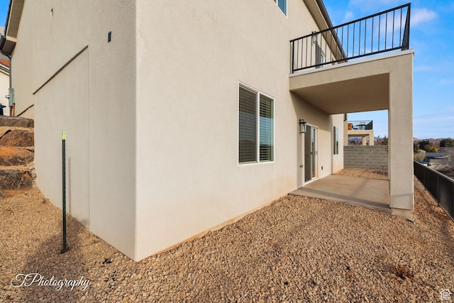 view of property exterior featuring a balcony and a patio