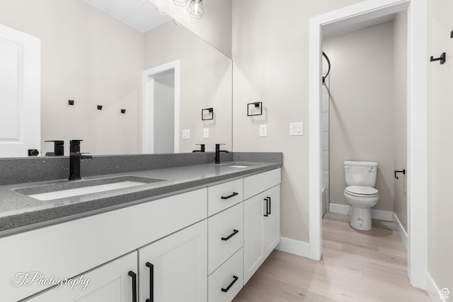 full bathroom featuring hardwood / wood-style floors, vanity, toilet, and bathtub / shower combination