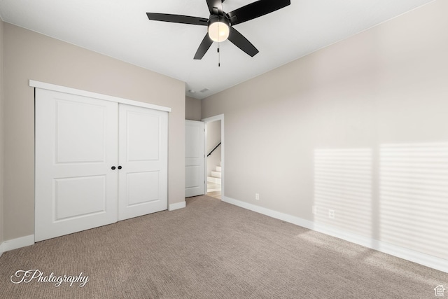 unfurnished bedroom featuring carpet flooring, a closet, and ceiling fan