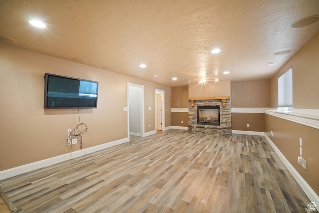 6190 W 5950 S, Hooper, UT 84315 - unfurnished living room with a textured ceiling, wood-type flooring, and a fireplace