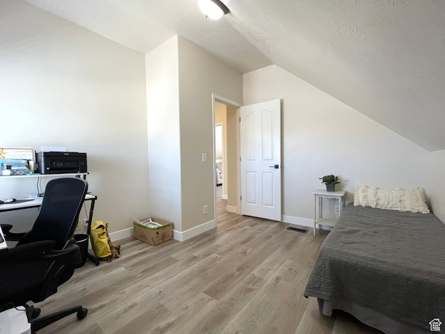 908 W Timpie Rd S, Tooele, UT 84074 - bedroom featuring vaulted ceiling, light wood-style flooring, a desk, baseboards, and a textured ceiling