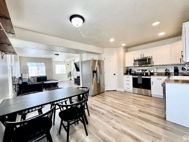 908 W Timpie Rd S, Tooele, UT 84074 - kitchen featuring appliances with stainless steel finishes, light wood-style floors, white cabinets, recessed lighting, and open floor plan