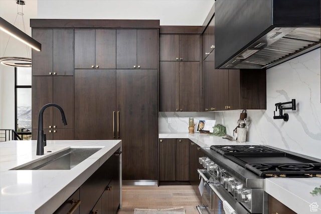1316 N Gold Mountain Cir, Heber City, UT 84032 - kitchen featuring wall chimney range hood, range with two ovens, dark brown cabinetry, light wood-style floors, and light stone counters