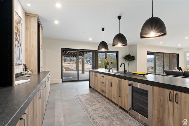 1316 N Gold Mountain Cir, Heber City, UT 84032 - kitchen featuring light brown cabinets, dark countertops, wine cooler, a sink, and modern cabinets