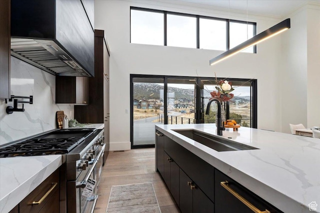 1316 N Gold Mountain Cir, Heber City, UT 84032 - kitchen featuring double oven range, a sink, wall chimney range hood, plenty of natural light, and a high ceiling