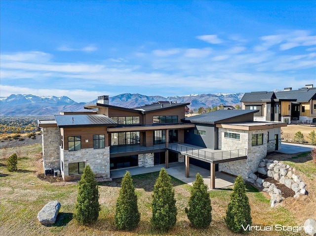 1316 N Gold Mountain Cir, Heber City, UT 84032 - rear view of house featuring stone siding, a mountain view, a balcony, and a chimney