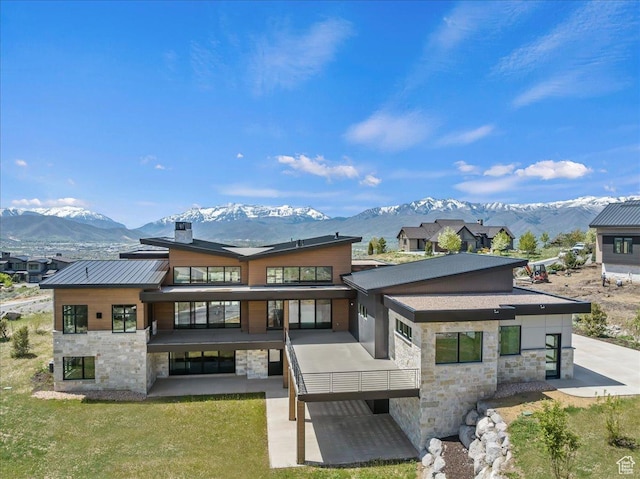 1316 N Gold Mountain Cir, Heber City, UT 84032 - back of house with stone siding, a mountain view, a patio area, and a chimney