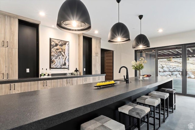 1316 N Gold Mountain Cir, Heber City, UT 84032 - kitchen featuring light brown cabinets, dark countertops, a breakfast bar, modern cabinets, and recessed lighting
